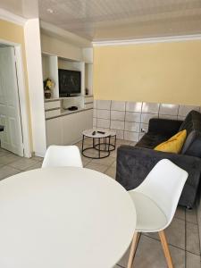 a living room with a couch and two white chairs at LPM Guests at 21st in Pretoria +18 photos