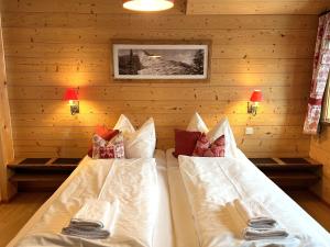 two beds in a room with wooden walls at Holiday Home st martin chalets-1 by Interhome in Sankt Martin
