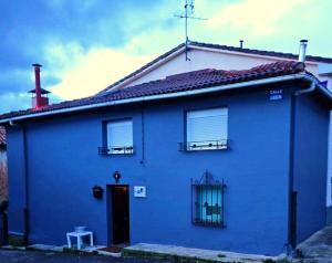 una casa blu con due finestre e una porta di Casita Singular a Santibáñez de la Peña