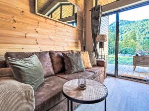 a living room with a couch and a table at Holiday Home Tiny Haus Glockenalm-Haus zum Glück by Interhome in Aurach