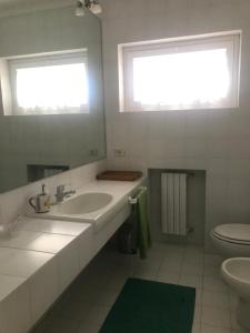 een witte badkamer met een wastafel en een toilet bij Villa Degli Olivi in Pula