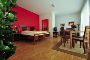 a bedroom with a bed with a red wall at Heldts Aparthotel in Eckernförde