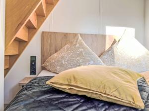 a bedroom with a bed with a wooden headboard and pillows at Holiday Home Tiny Haus Glockenalm-Chalet Alpenzauber by Interhome in Aurach