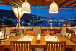 a restaurant with tables and chairs and a view of the city at Vrahos Boutique Hotel in Karavostasi