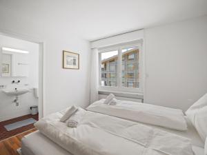 a white room with two beds and a sink at Apartment Nr-14 Haus Astoria by Interhome in Lenzerheide