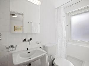 a white bathroom with a sink and a toilet at Apartment Nr-14 Haus Astoria by Interhome in Lenzerheide +19 photos