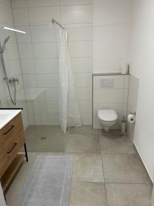 a white bathroom with a toilet and a shower at Gästeapartment - Kirchweg 4 in Rainau in Rainau +3 photos