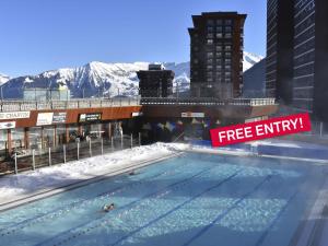a swimming pool with a free entry sign in a city at Studio Soyouz Vanguard-102 by Interhome in Le Corbier