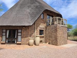 a small brick building with a thatched roof at Makhato Bush Lodge 17 in Bela-Bela
