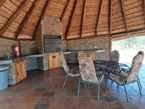 a dining room with a table and chairs in a kitchen at Makhato Bush Lodge 17 in Bela-Bela