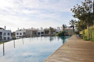 a swimming pool with a wooden walkway and houses at Charming Cascais Apt. in Cascais