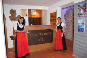 two women standing next to a sign in a store at Hotel Garni Snaltnerhof in Ortisei