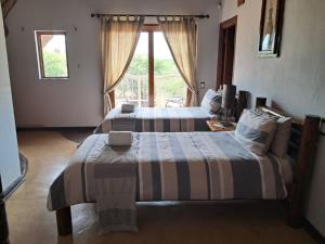 a bedroom with two beds and a window at Makhato Bush Lodge 17 in Bela-Bela