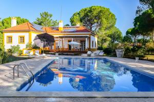 a house with a swimming pool in front of a house at Villa 97 by Trip2Portugal in Alcácer do Sal
