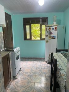 a kitchen with blue walls and a refrigerator and a table at Casa da Inês in Santa Teresa