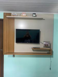 a tv on a wall with a person on it at Casa da Inês in Santa Teresa