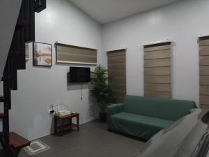 モアルボアルにあるGrae’s Apartelleの緑のソファとテレビのあるリビングルーム
