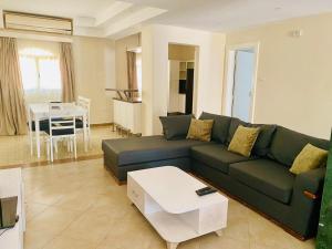 赫尔格达Hurghada-Magawish Villa 6的客厅配有绿色沙发和桌子