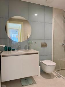 a bathroom with a sink and a toilet and a mirror at Aglaya Tokyo - Luxury 2 Bedroom Apartment in Belgrade