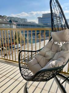 a chair sitting on a balcony with a view of the water at Aglaya Tokyo - Luxury 2 Bedroom Apartment in Belgrade