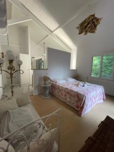 a bedroom with a bed and a couch in it at Maison de Famille entre Biarritz et Hossegor in Saint-Martin-de-Seignanx