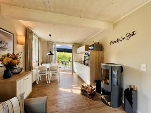 Una sala de estar con chimenea y una cocina. en Ferienhaus Mee h r Zeit 07 Feriendorf Klein Stresow Rügen by ruyastay, en Putbus