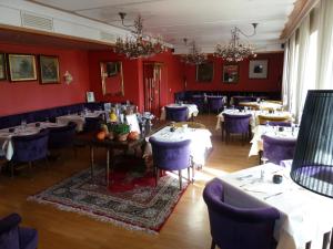 uma sala de jantar com mesas brancas e cadeiras azuis em Hotel zum alten Brauhaus em Dudeldorf