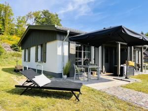 ein kleines Haus mit einem Tisch und einem Sonnenschirm in der Unterkunft Ferienhaus Svantevit 31 Feriendorf Klein Stresow Rügen by ruyastay in Putbus