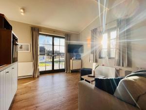 ein Wohnzimmer mit Couch und großem Fenster in der Unterkunft Ferienhaus Svantevit 31 Feriendorf Klein Stresow Rügen by ruyastay in Putbus