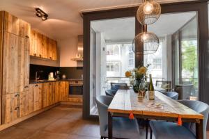 eine Küche und ein Esszimmer mit einem Holztisch und Stühlen in der Unterkunft Ferienwohnung Reetkoje in der Villa Martha Binz in Binz