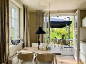 Ferienhaus Strandflieder 05 Feriendorf Klein Stresow Rügen by ruyastay في بوتبوس: مطبخ وغرفة طعام مع طاولة وكراسي