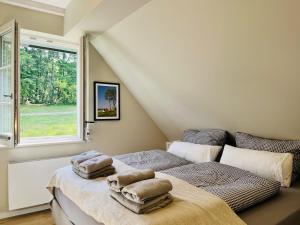 Ferienhaus Strandflieder 05 Feriendorf Klein Stresow Rügen by ruyastay في بوتبوس: غرفة نوم بها سريرين ونافذة