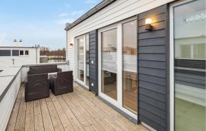 eine Terrasse mit einem Tisch und Stühlen auf einem Haus in der Unterkunft Beautiful Home In Tossens With Sauna in Tossenserdeich