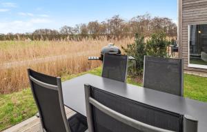 ein Tisch und Stühle mit Blick auf ein Feld in der Unterkunft Beautiful Home In Tossens With Sauna in Tossenserdeich