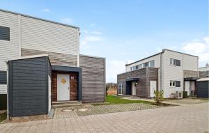 ein Haus mit einer schwarzen Tür und zwei Gebäuden in der Unterkunft Beautiful Home In Tossens With Sauna in Tossenserdeich + 13 Fotos