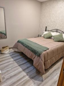 ein Schlafzimmer mit einem Bett und einem Holzboden in der Unterkunft Casa Rural LA MIELGUERA in Villalcázar de Sirga