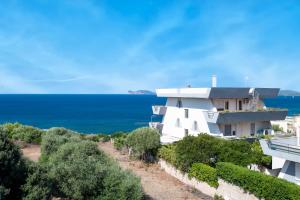 un edificio blanco con el océano en el fondo en Amare Penthouse with Hot Tub Facing the Sea, en Alghero