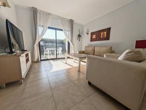 a living room with a couch and a television at Sagres Time Apartamentos in Sagres