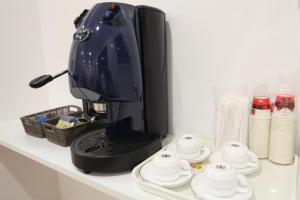 a black coffee maker on a counter with cups and saucers at Vatican Bliss in Rome
