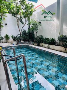 a swimming pool with blue tiles in a building at Byta House Homestay in Kinh Dinh
