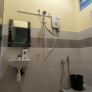 ein Badezimmer mit Dusche und Waschbecken in der Unterkunft Homestay Cikgu CT in Muadzam Shah