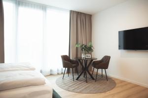 a bedroom with a bed and a table with chairs at Black Forest Suites Achern in Achern