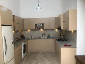 a kitchen with white cabinets and a washer and dryer at Beverly Edge Villa in Sri Jayewardenepura Kotte +11 photos