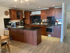 a kitchen with wooden cabinets and a counter top at 2 Bed Ilfracombe Seafront Apartment with stunning views in Ilfracombe