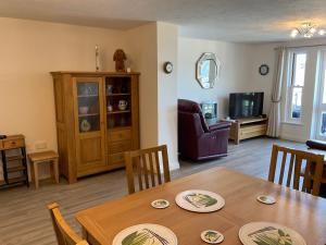 Una sala de estar con una mesa y un comedor. en 2 Bed Ilfracombe Seafront Apartment with stunning views, en Ilfracombe