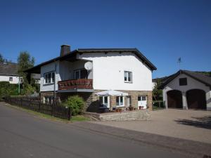 ein weißes Haus mit einem Balkon und einer Auffahrt in der Unterkunft Apartment in Halenfeld near Ski Slope in Sellerich