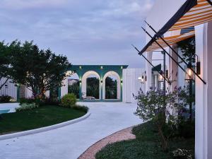 a driveway leading to a building with a patio at Muse Garden in Shanghai