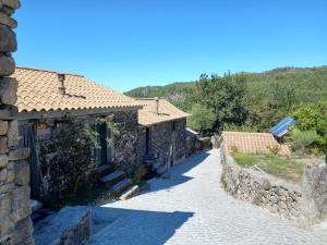 a stone house with a pathway in a village at Horizontes Serranos in Tondela