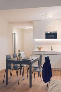 a kitchen with a table with a laptop on it at HITrental Town Hall Apartments in Basel