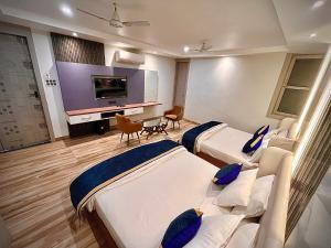 a hospital room with two beds and a flat screen tv at Hotel Lata Continental in Kānpur +45 photos